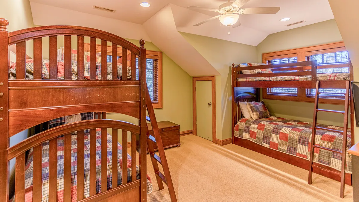 A playful bunk room featuring colorful bedding and sturdy wooden bunk beds. The room is designed for fun, with ample space for sleepovers, games, and late-night storytelling.